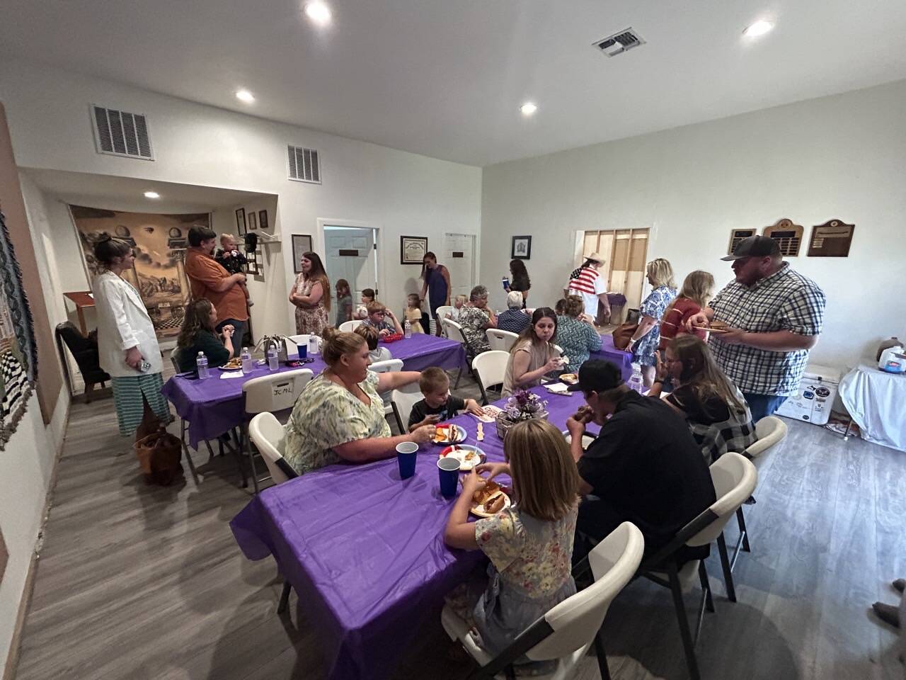 Multi-generational lodge family dinner — children, parents, and elders seated together in the dining hall.